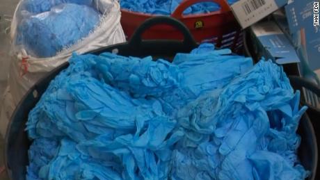 Piles of dirty, suspected second-hand nitrile gloves were found in a raid on a warehouse in Bangkok, December 2020. The Thai FDA said fraudulent companies package gloves like these for resale around the world.  