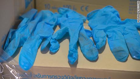Nitrile gloves shipped to the US by Thai company Paddy the Room Trading Company. These examples, seen by CNN, show clear signs of previous use -- hand-writing in pen and other soiling. 